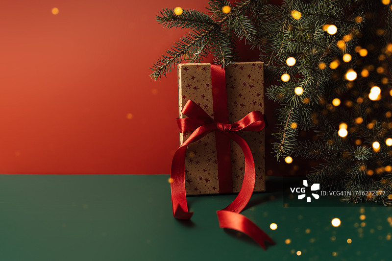 圣诞树上有花环和礼物，前面是红色的背景图片素材