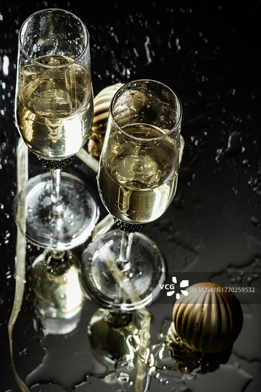两只香槟酒杯映照在新年的玻璃背景里图片素材