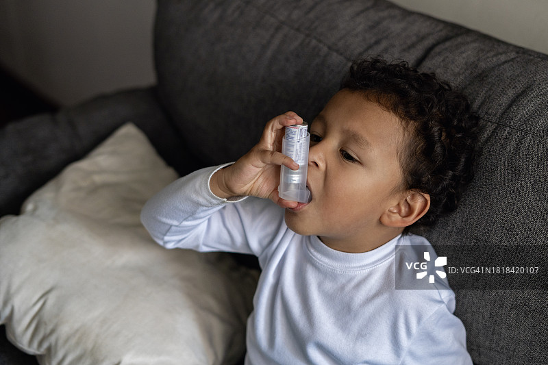 孩子第一次使用哮喘吸入器。图片素材