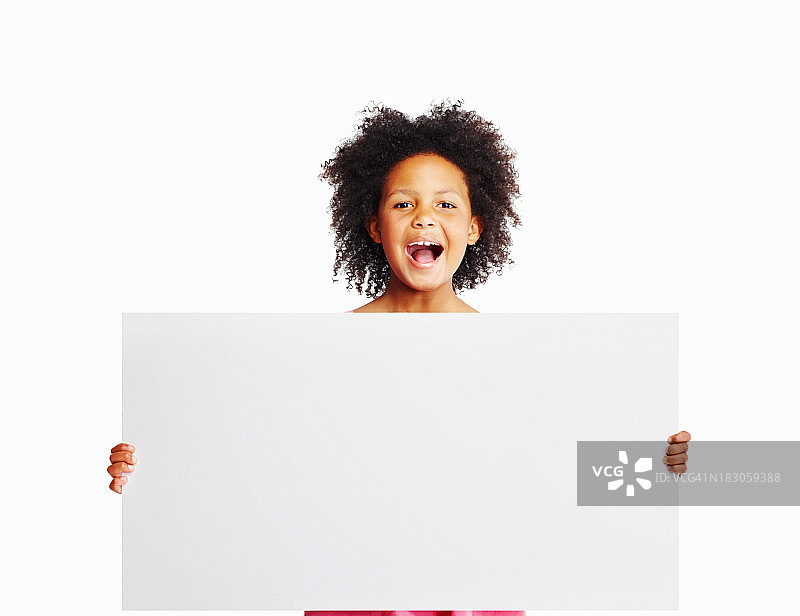 可爱的女孩拿着大广告牌对着白色的copyspace图片素材
