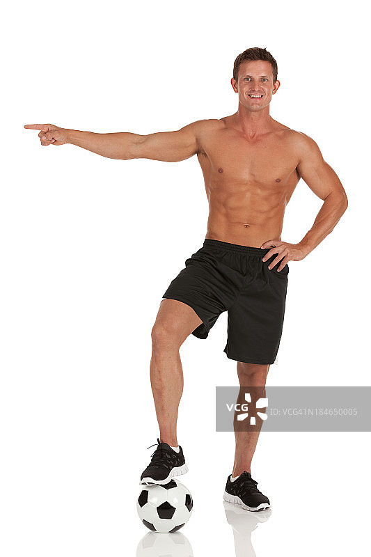 赤裸上身，一只脚踩在足球上的男人图片素材
