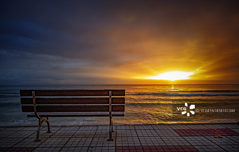 日落时分，沙滩上空无一人的长椅，映衬着天空图片素材