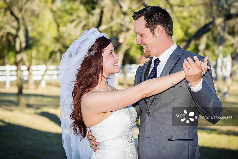 美国德克萨斯州，一对年轻的新婚夫妇微笑着看着对方图片素材