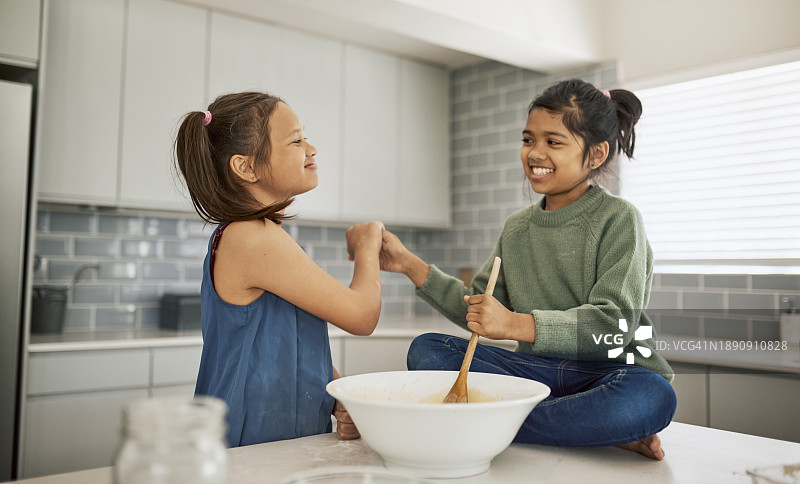 两个快乐的女孩在厨房烤面包图片素材