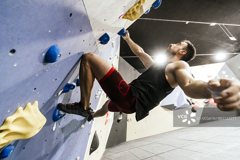 运动员在健身房的抱石墙上攀爬图片素材