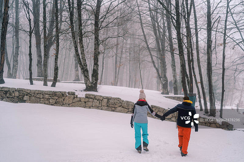 男人和女人手牵着手走过雪堆图片素材