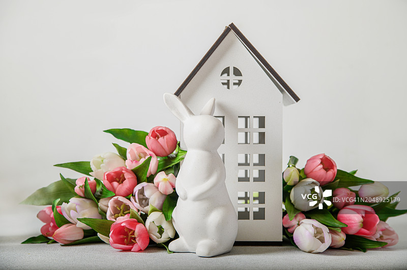 复活节贺卡。兔子，房子，彩色郁金香和复印空间图片素材