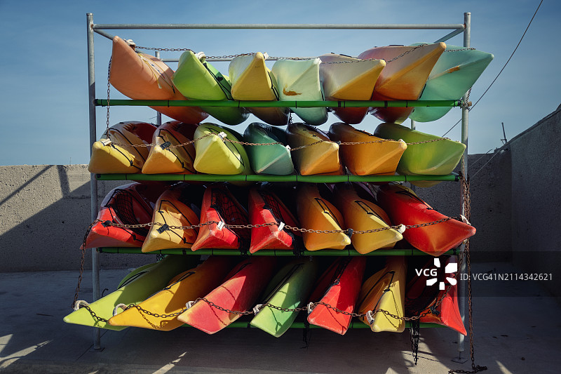 五颜六色的独木舟堆放在马略卡岛的波伦萨港，刚刚结束了帆船赛，西班牙。图片素材