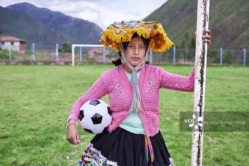 图为来自秘鲁的克丘亚族足球运动员在足球场上拿着球图片素材