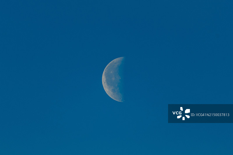 低角度的月亮对着清澈的蓝天图片素材