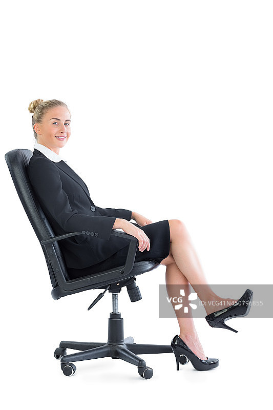 华丽别致的女商人坐在办公椅上图片素材