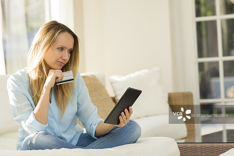 一个白人女人用平板电脑在网上购物图片素材