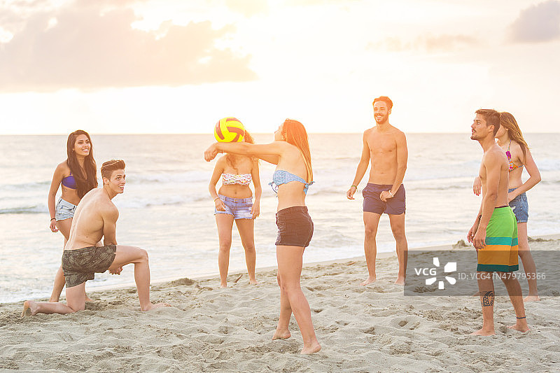 一群朋友在沙滩上玩球图片素材
