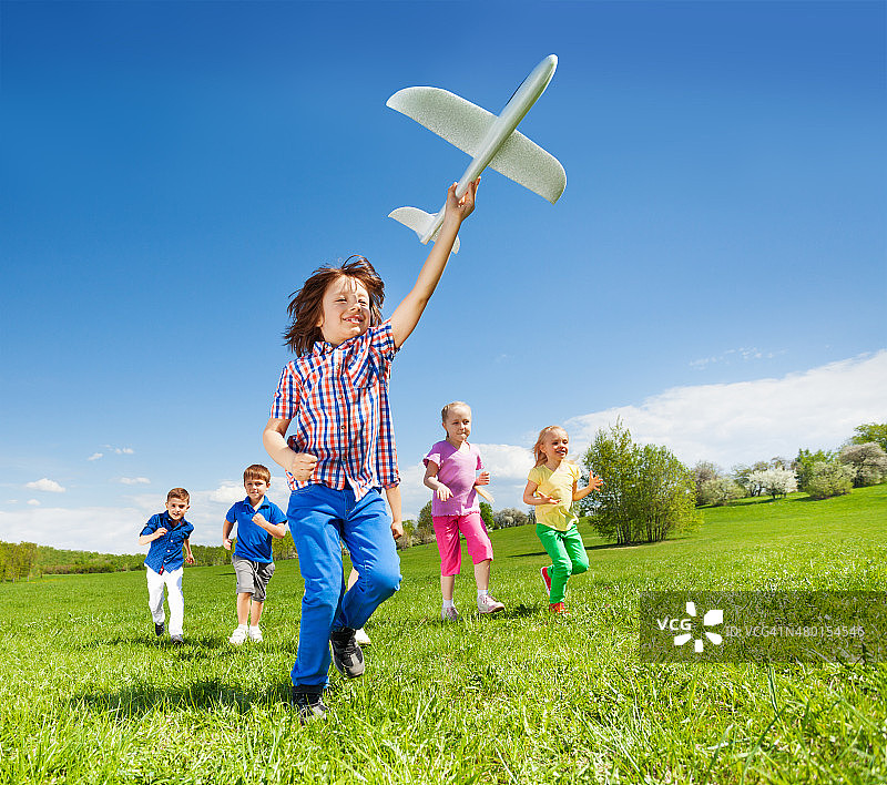 积极奔跑的孩子和男孩拿着飞机玩具图片素材