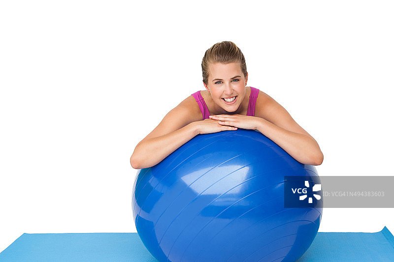 一个带着健身球的健康微笑女人的肖像图片素材