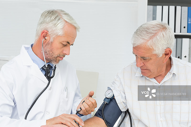 医生给他退休的病人量血压图片素材