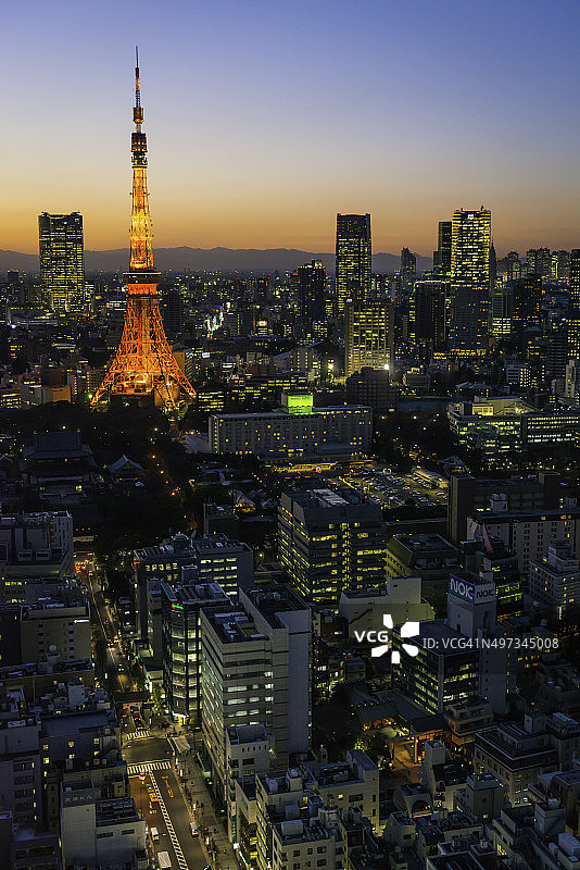 东京塔拥挤的未来主义城市景观在日落时照亮日本图片素材