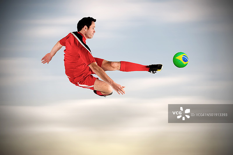 穿红色衣服踢球的足球运动员图片素材