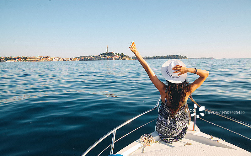 年轻的褐发女子在船上享受夏日时光图片素材