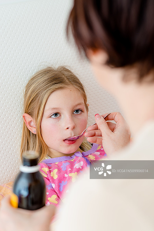 生病的小女孩正在吃咳嗽药图片素材