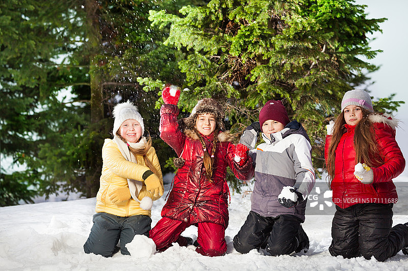 快乐的朋友们在冬天的森林里玩雪球图片素材