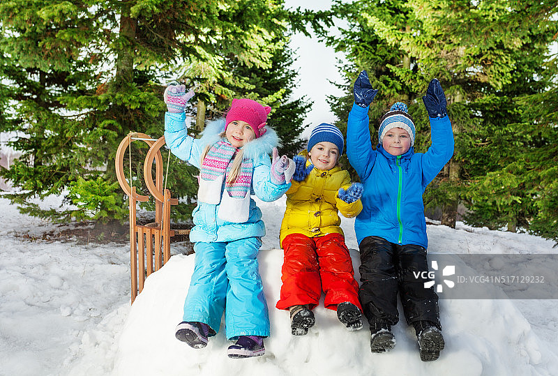 一群小孩坐在公园的雪墙上图片素材