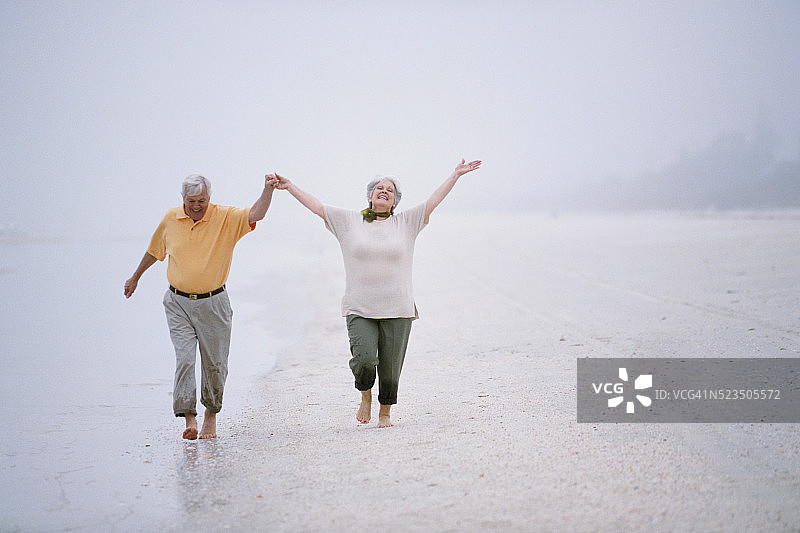老年夫妇享受迷雾海滩图片素材