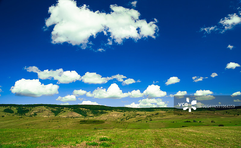 绿色的田野，蓝色的天空和淡淡的云彩图片素材