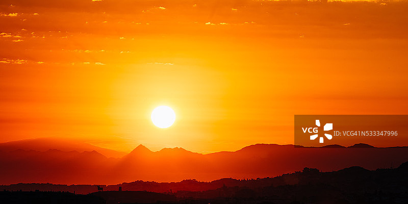 惊人的日落日出与太阳在黑暗的山地面剪影图片素材