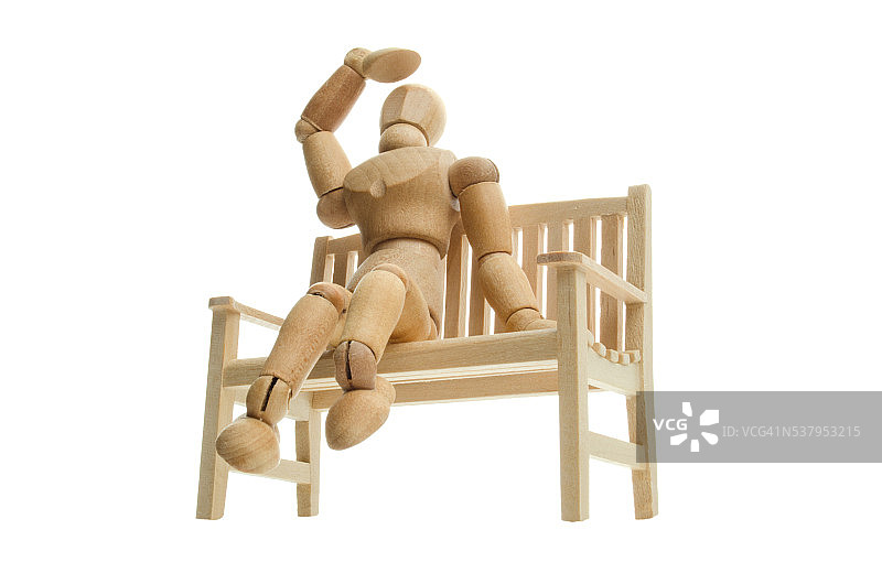 木制人体模型在长凳上放松，抬头看图片素材