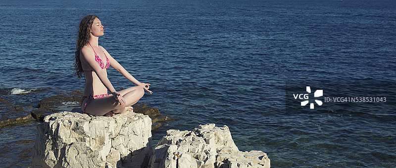 坐在海边岩石上的女人图片素材