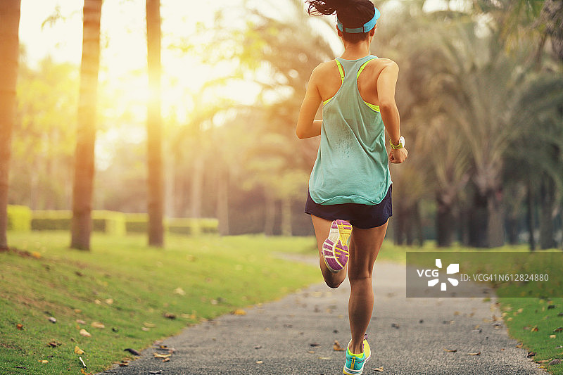 健康的生活方式年轻的运动亚洲女人在热带公园跑步图片素材