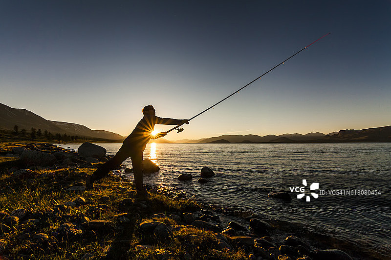 日落时湖面上的渔夫图片素材