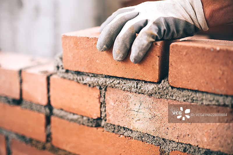 工业砌砖工人在建筑工地安装砖的特写图片素材