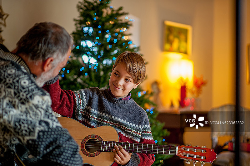 父亲和儿子在圣诞节弹奏吉他图片素材