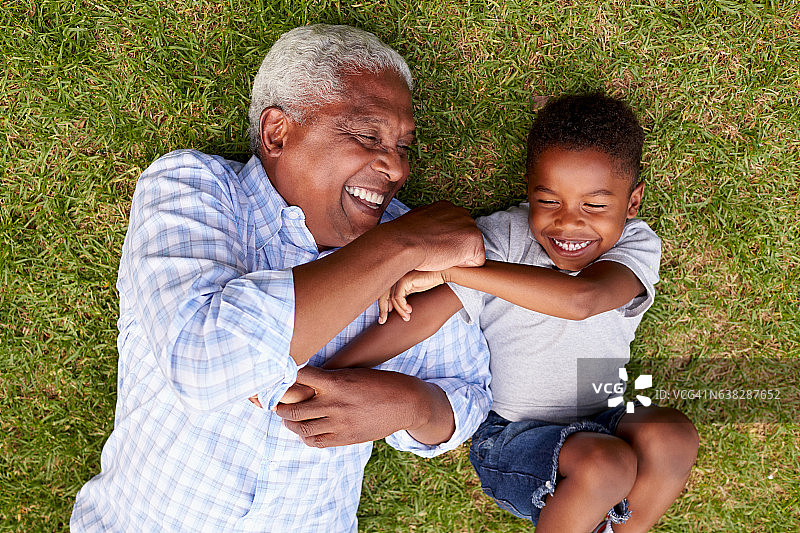 爷爷和孙子躺在草地上玩，鸟瞰图片素材