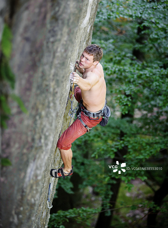 肌肉发达的攀岩者爬上悬挑的悬崖图片素材
