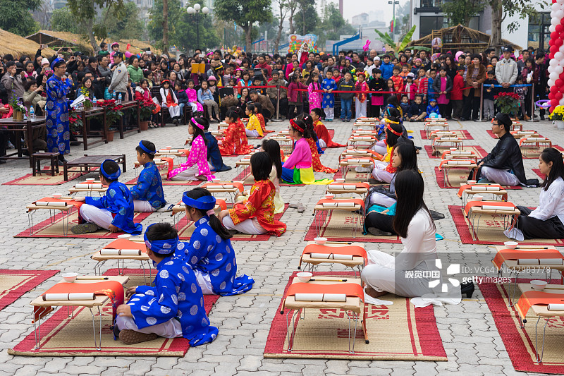 越南河内——2015年2月7日:在越南首都河内明开文中学举办的农历新年庆祝活动上，身着传统服饰的学生们正在学习书法图片素材