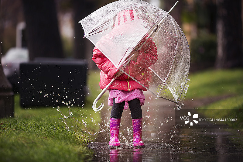 小女孩在加州的大雨中玩耍。图片素材