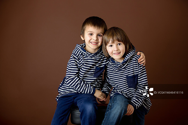 两个男孩的双肖像，兄弟，孤立在棕色图片素材