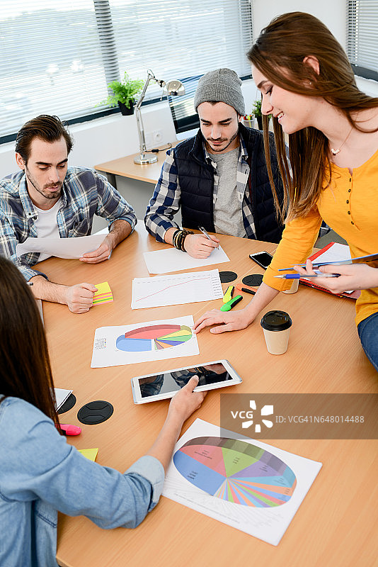 一群穿着休闲装的年轻潮人创意商务人士在一家初创公司的会议室里一起工作图片素材