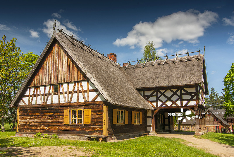 来自波兰Olsztynek的Masuria地区的带有拱廊扩建、半木墙和茅草屋顶的小屋。图片素材