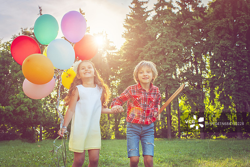 小男孩和小女孩拿着气球图片素材