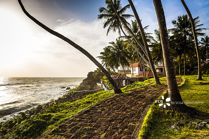 印度喀拉拉邦瓦尔卡拉海滩附近通往度假胜地的小路上的金光图片素材