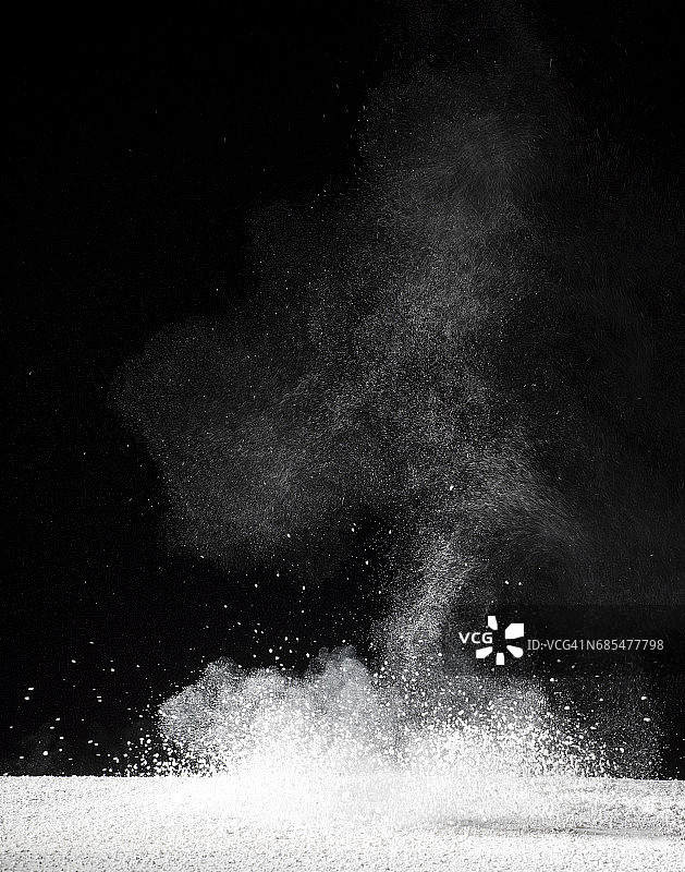 由白色和黑色背景组成的粉末状粒子云的爆炸图片素材