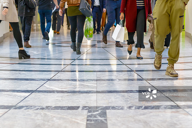 一种现代地板，背景是人群行走的双腿图片素材