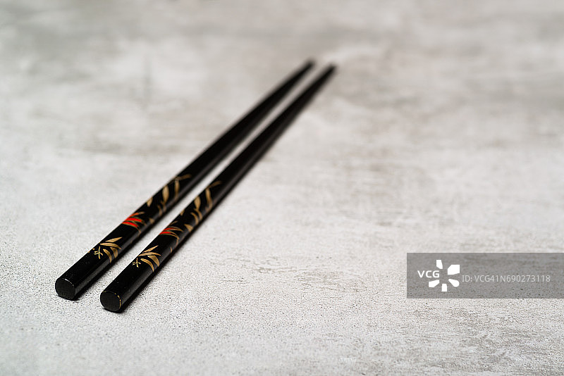 黑色筷子在混凝土背景与选择性焦点图片素材