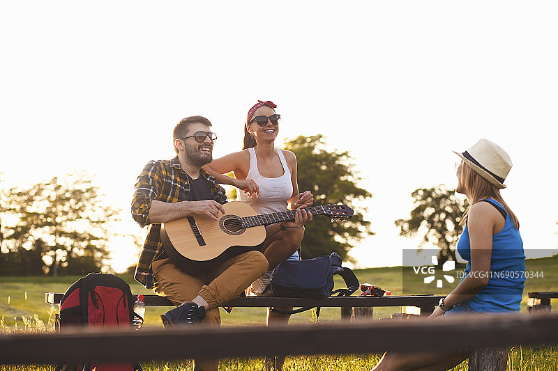 年轻人露营时在户外弹吉他图片素材