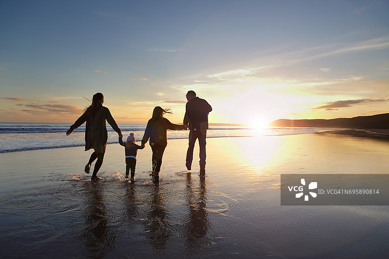 日落时分一家人在海滩上散步图片素材