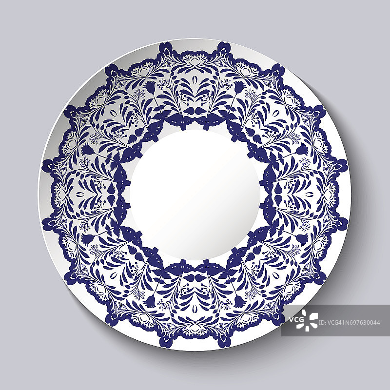 带有蓝色花卉图案的装饰性陶瓷盘。图片素材